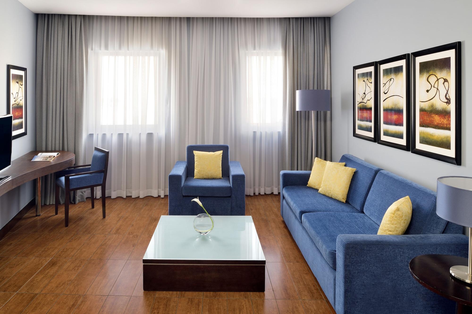 Moevenpick Hotel Apartments Al Mamzar Dubai Bagian luar foto A living room with a sofa