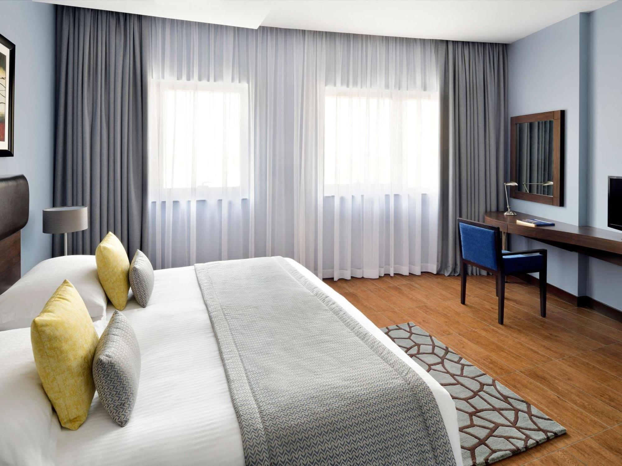 Moevenpick Hotel Apartments Al Mamzar Dubai Bagian luar foto A bedroom at the hotel